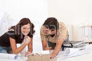 Smiling man and woman working at architect office