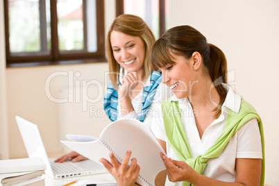 Student at home - two woman with book and laptop