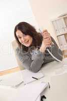 Happy businesswoman holding phone at office