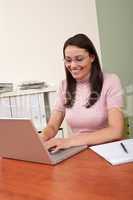 Smiling businesswoman with laptop at office