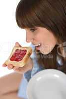 Happy teenager in pajamas eating healthy toast
