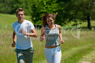 Young couple jogging outdoors in spring nature