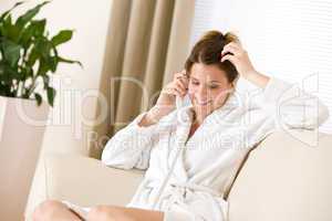 Happy woman in white bathrobe with phone