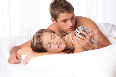 Young man suprised by alarm clock