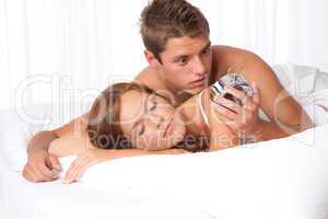 Young man suprised by alarm clock