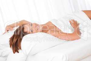 White lounge - Smiling  brown hair woman lying in white bed