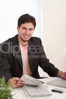 Successful modern businessman with laptop and newspaper