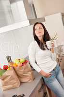 Young smiling woman with groceries in the kitchen