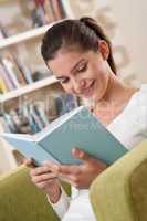 Students - Happy teenager with book sitting on armchair
