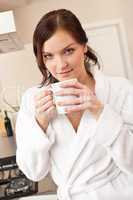 Young woman enjoying cup of coffee in kitchen