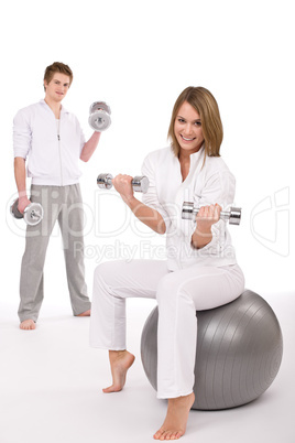 Fitness - Young couple exercise with weights and ball