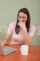 Smiling secretary with coffee and laptop at office