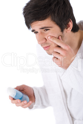 Facial care - Young man cleaning face with lotion