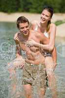 Piggyback - happy couple enjoy sun in water