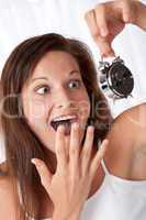 Surprised woman watching alarm clock