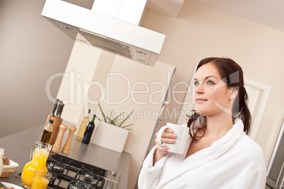 Young woman enjoying cup of coffee in kitchen