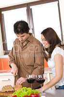 Happy couple cut bread in modern kitchen