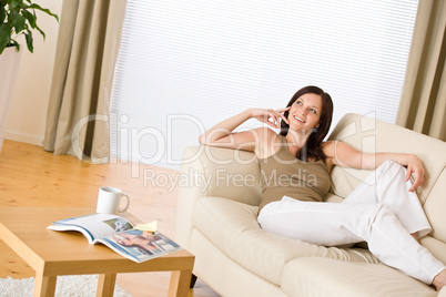 Young woman with magazine and coffee in lounge