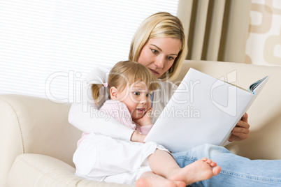 Mother with surprised little girl read book