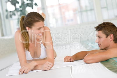 Young happy couple relax at swimming pool