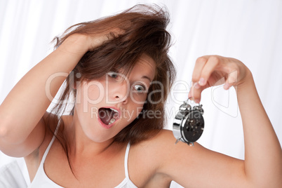 Surprised woman watching alarm clock