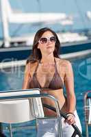 Beautiful young woman standing on luxury boat