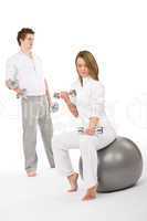 Fitness - Young couple exercise with weights and ball