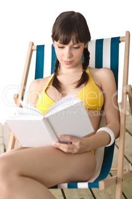 Beach - Young woman in bikini sunbathing with book