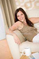 Young woman with magazine and coffee in lounge