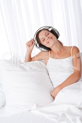 Brown hair woman with headphones sitting on sofa