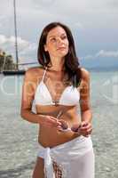 Brown hair fashion model in bikini by the sea