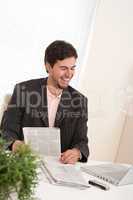 Successful modern businessman with laptop and newspaper