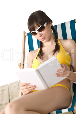 Beach - Young woman in bikini sunbathing with book