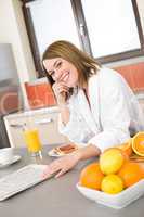 Breakfast - Smiling woman reading newspaper in kitchen