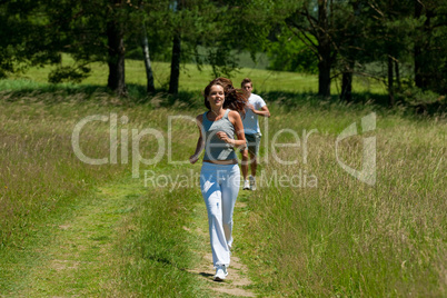 Young couple jogging outdoors in spring nature