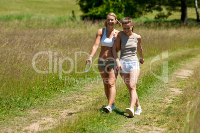 Female couple walking in meadow