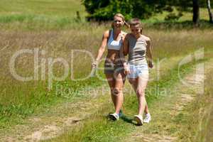 Female couple walking in meadow