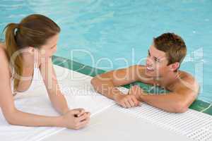 Swimming pool - young happy couple chat on poolside