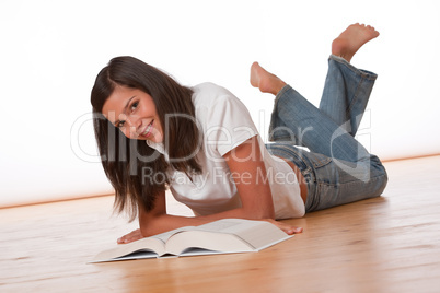 Happy teenager lying down with book