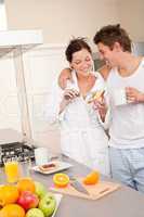 Happy couple having breakfast in the kitchen