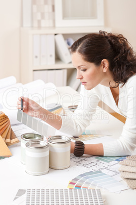 Young female interior designer at office with paint