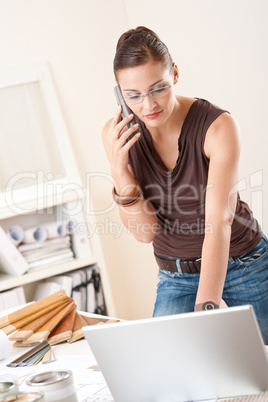 Female interior designer with laptop and phone