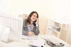 Young executive woman talking on phone at office