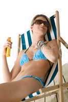 Beach - Young woman apply suntan lotion