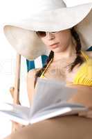 Beach - Young woman in bikini sunbath with book
