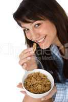 Smiling woman eat whole wheat cereal in pajamas