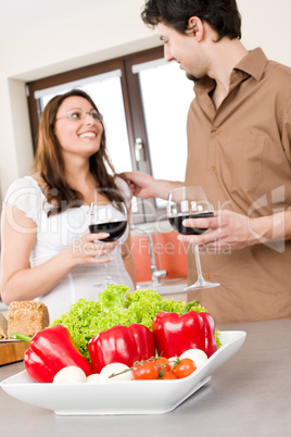 Happy couple in kitchen, focus on vegetable