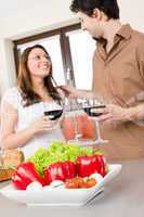 Happy couple in kitchen, focus on vegetable