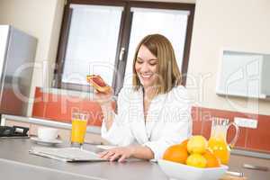 Breakfast - Smiling woman with orange juice in kitchen