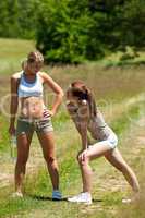 Two young women exercising in a meadow